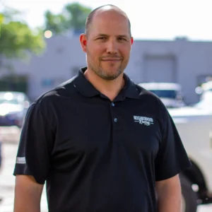 iQ Marketers portrait of Tom Meadows, an experienced roofing specialist in a black polo outdoors.